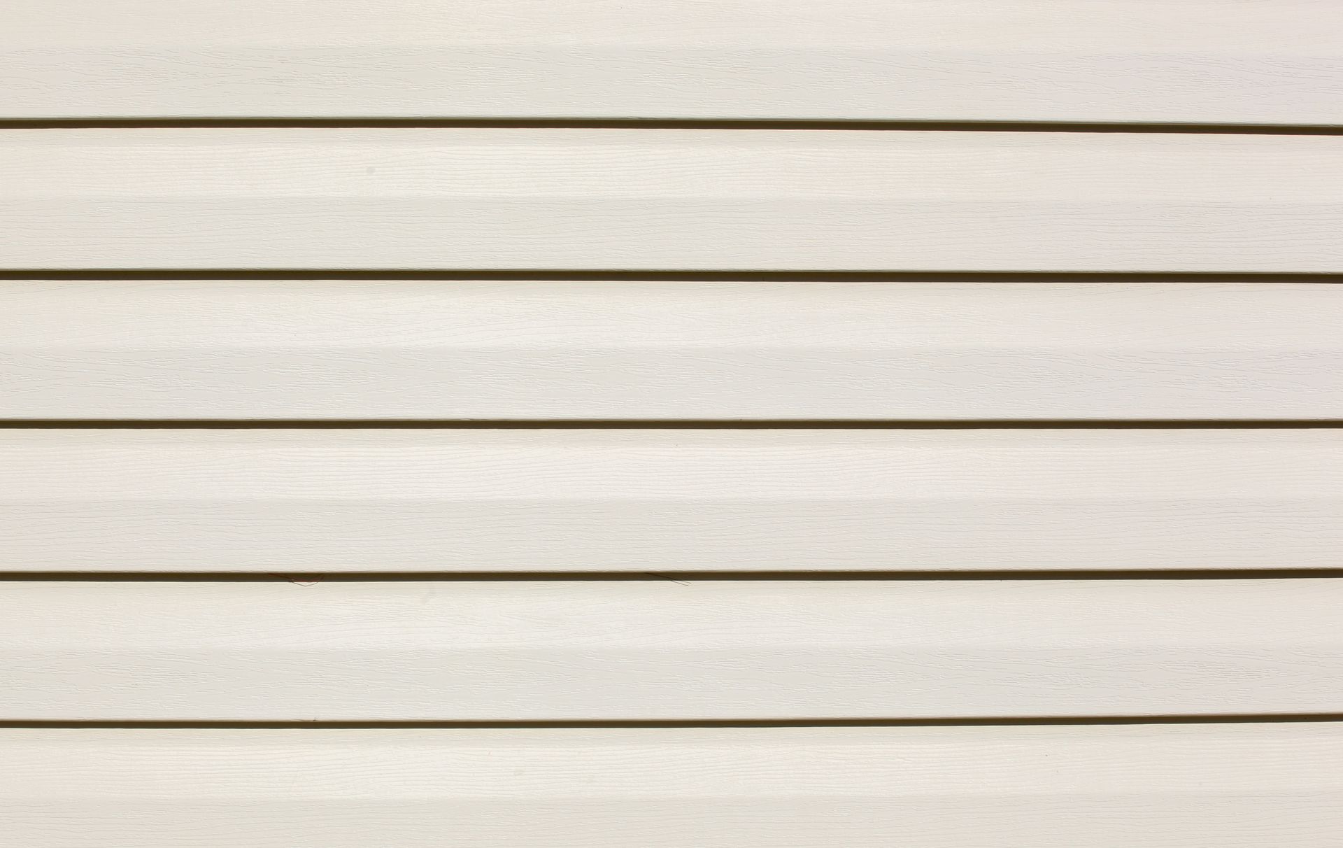 A close up of a white vinyl siding on a house.