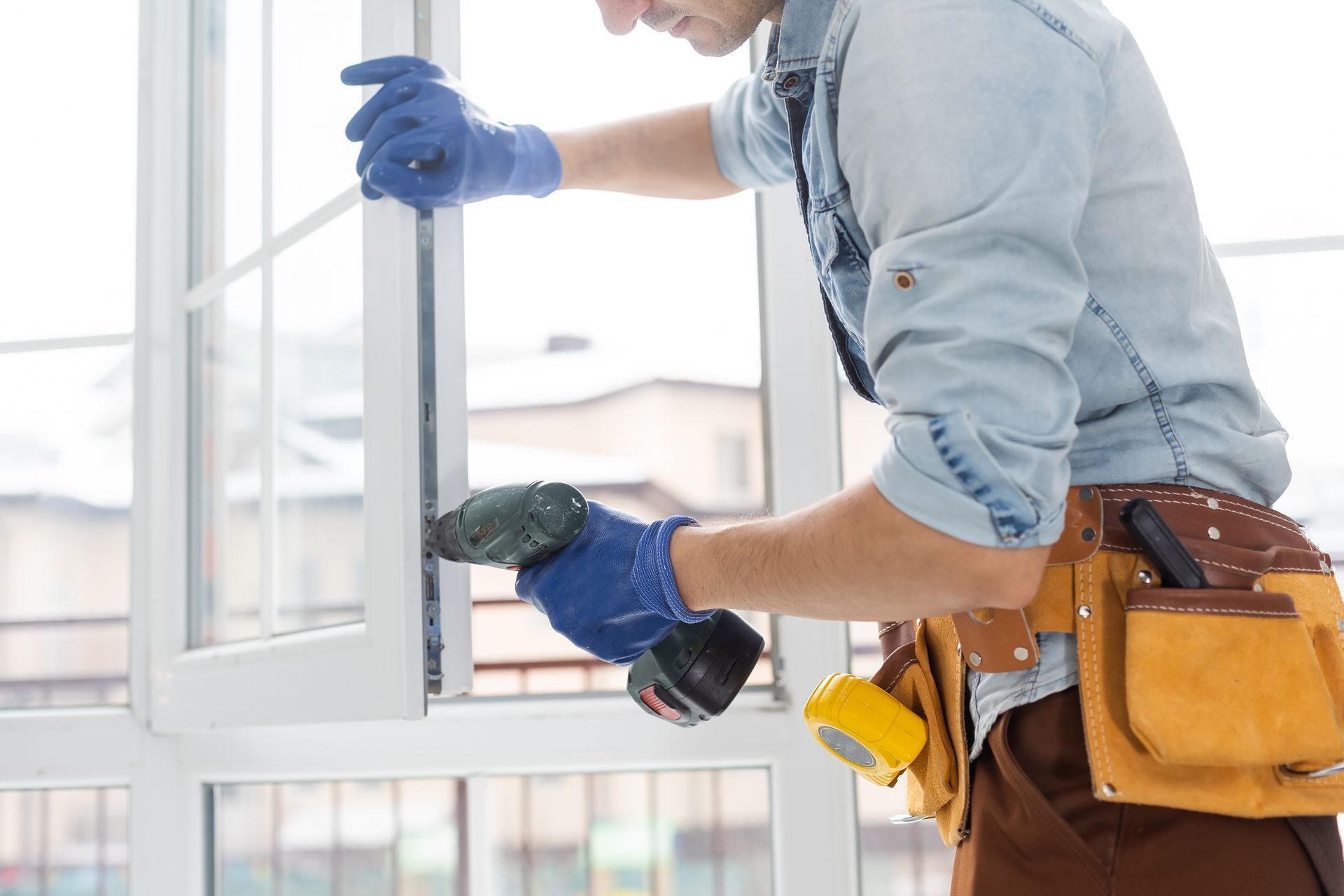 A man is installing a window with a drill.