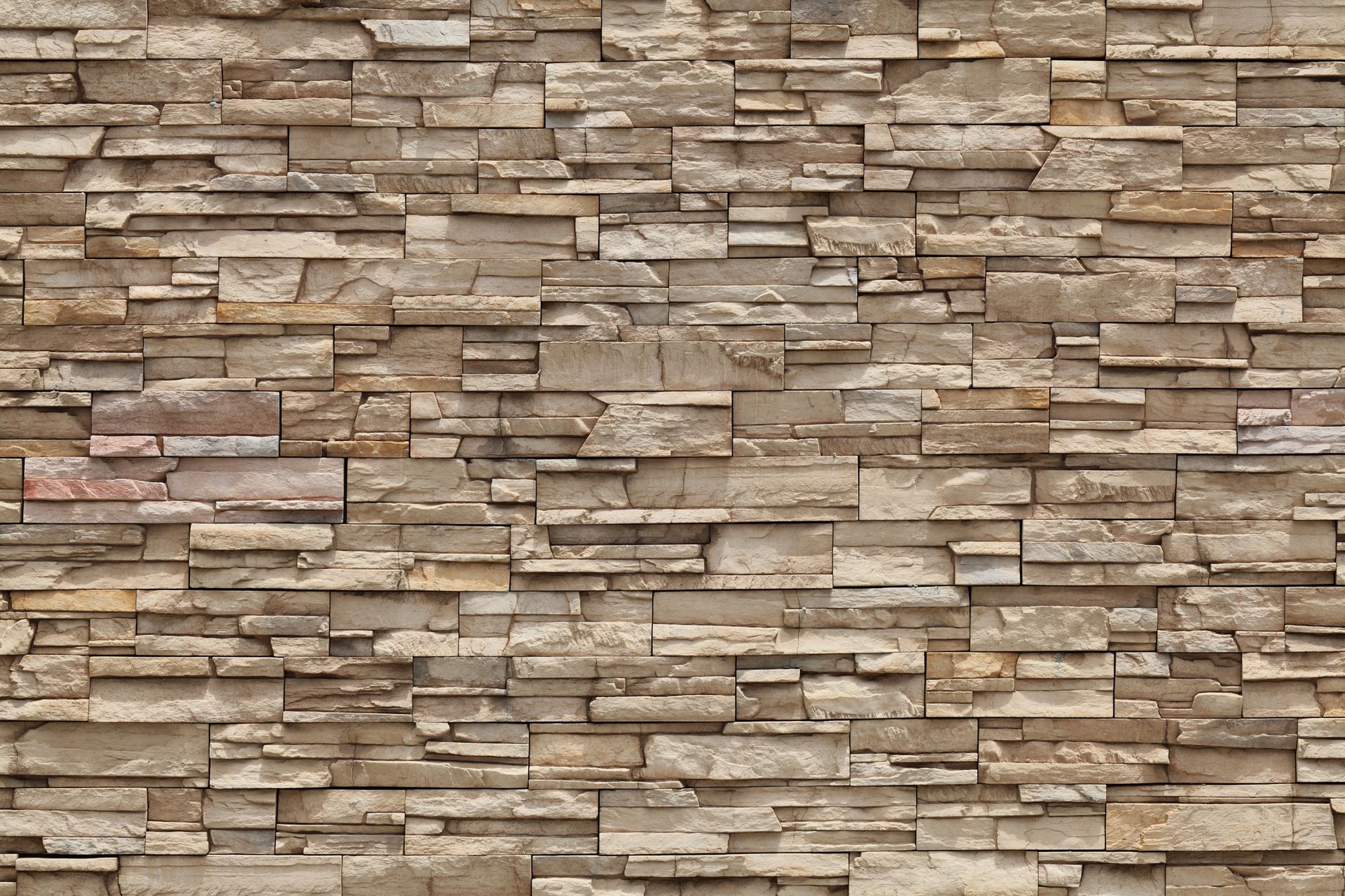 A close up of a stone wall with a brick pattern