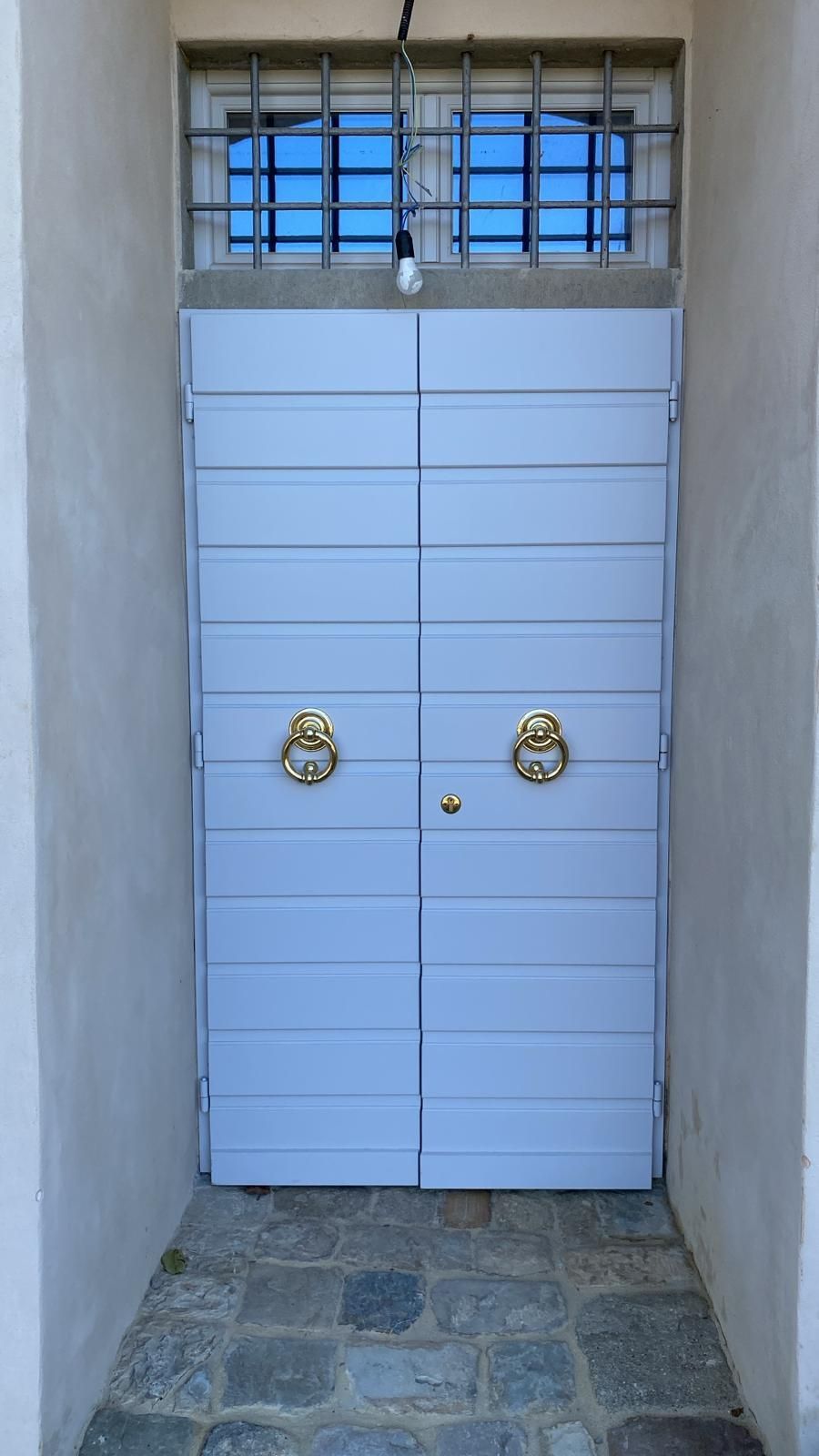 Porta bianca con maniglia e serratura argentate.