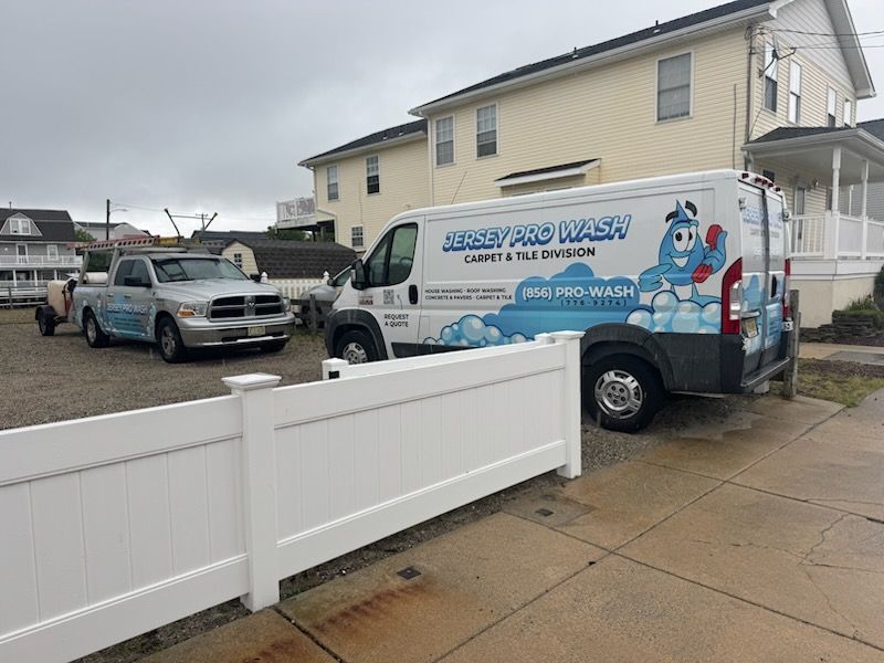 White van and truck parked near a building; 