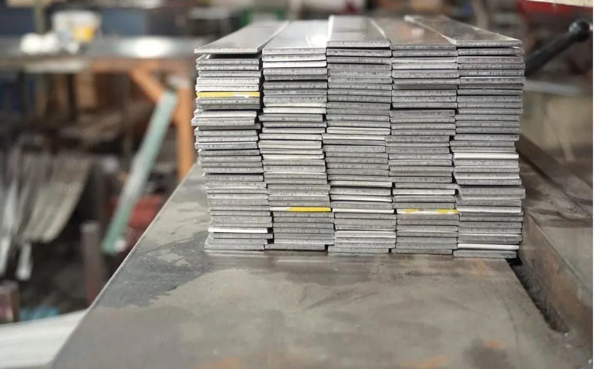 A Stack Of Metal Bars Sitting On Top Of Each Other On A Table — HardRok Engineering Pty Ltd In Mount Isa, QLD