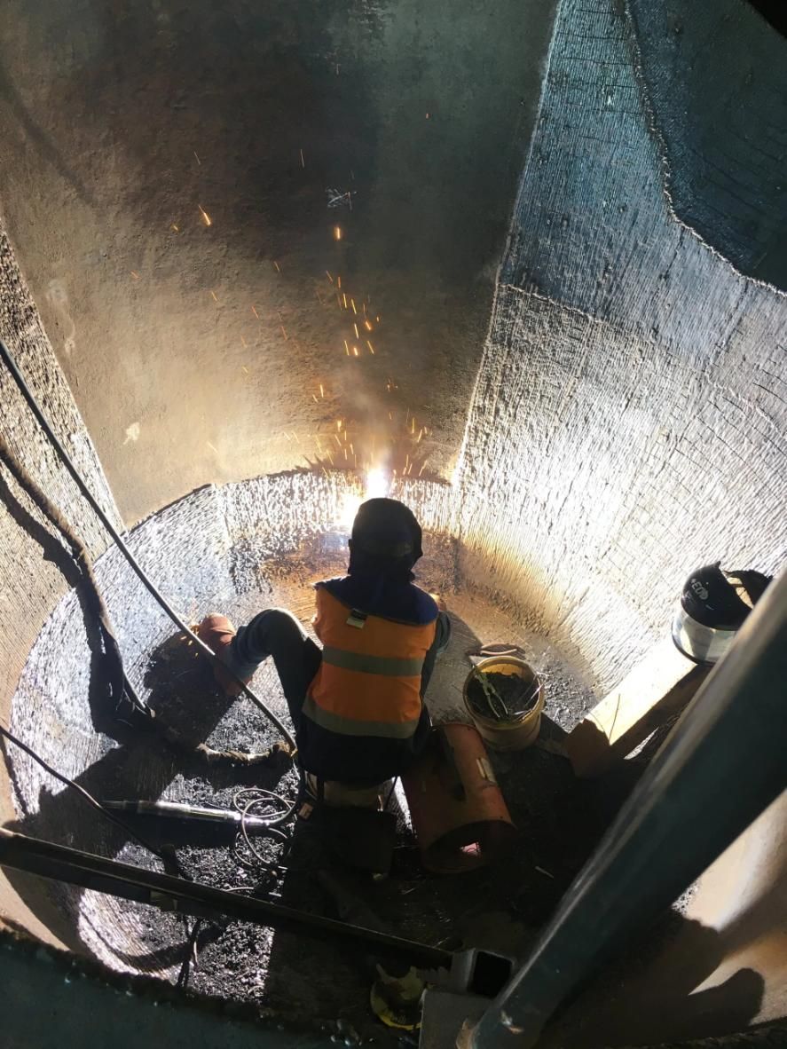 A Man Is Welding A Pipe In A Manhole — HardRok Engineering Pty Ltd In Mount Isa, QLD