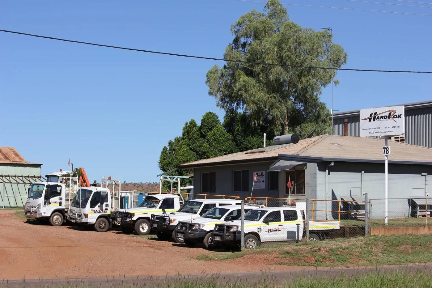 A Row Of Trucks Are Parked In Front Of A Building — HardRok Engineering Pty Ltd In Mount Isa, QLD