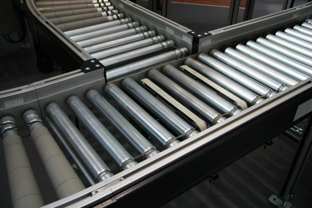 A Conveyor Belt With A Lot Of Rollers On It — HardRok Engineering Pty Ltd In Mount Isa, QLD