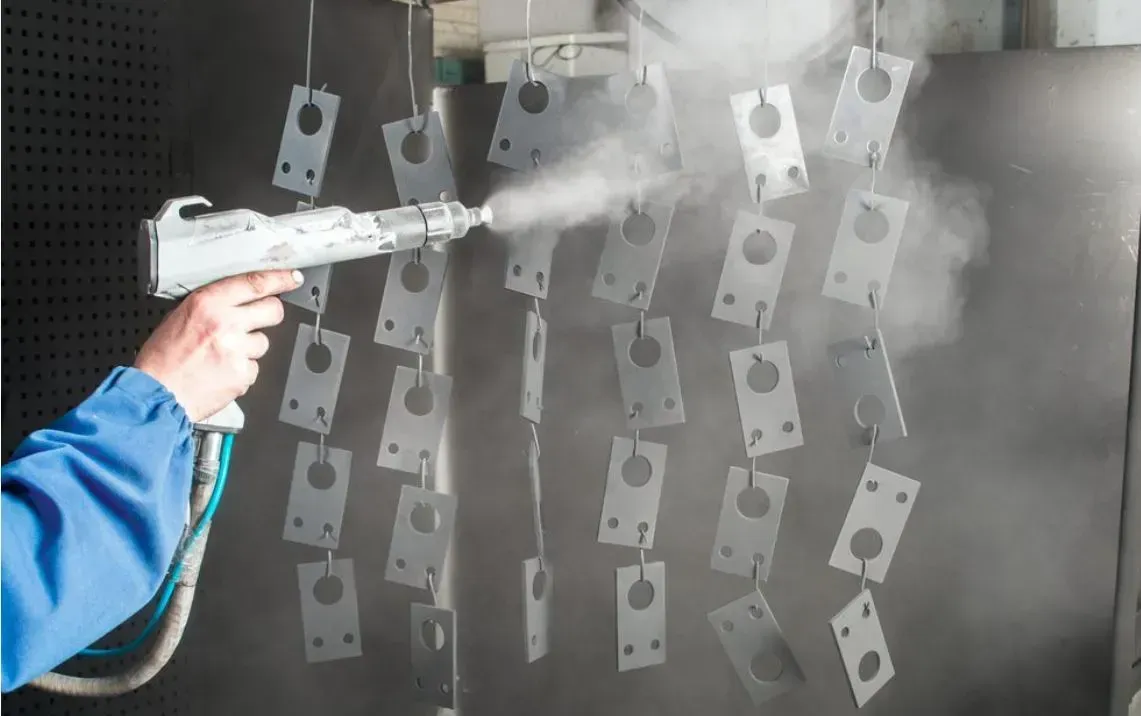A Person Is Spraying Powder Paint On A Piece Of Metal — HardRok Engineering Pty Ltd In Mount Isa, QLD