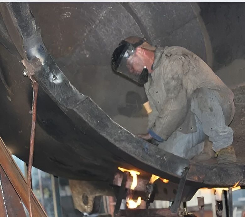 A Man Wearing A Welding Mask Is Working On A Large Piece Of Metal — HardRok Engineering Pty Ltd In Mount Isa, QLD