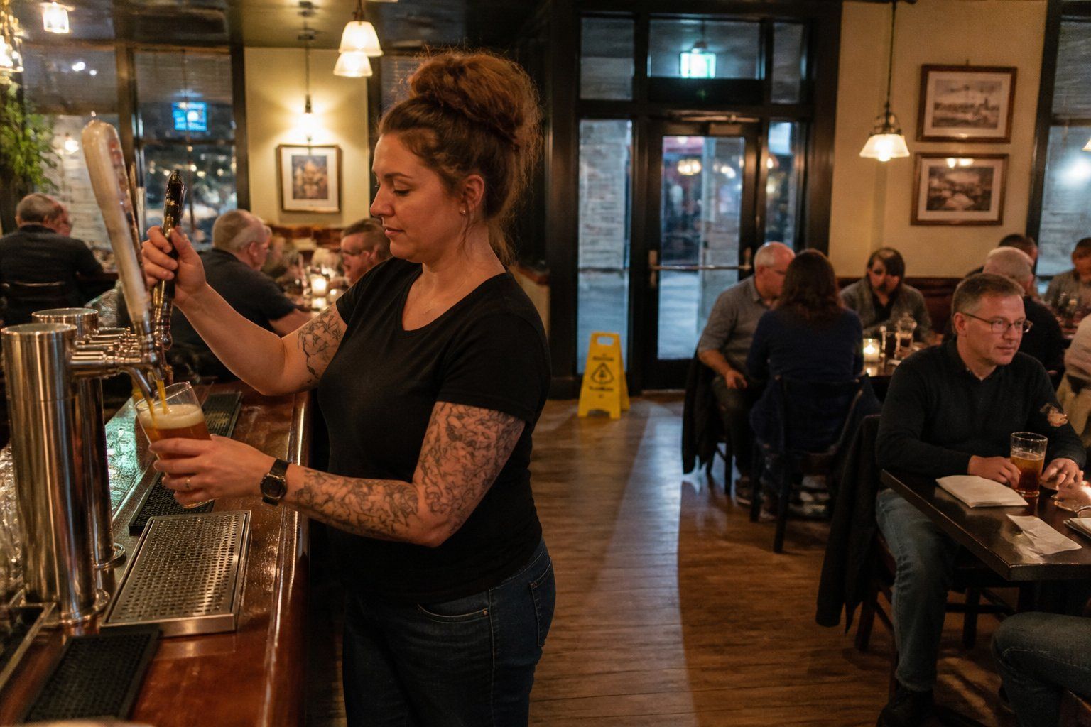 Bartender pouring a beer at a busy western Pennsylvania restaurant bar