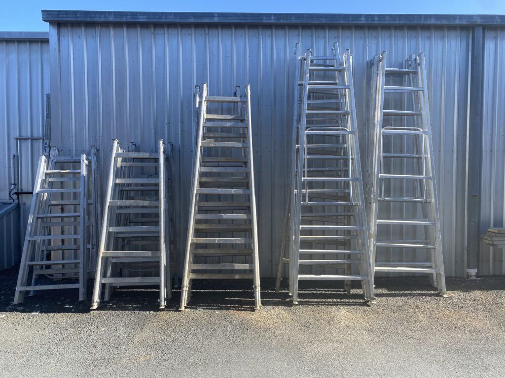 A Bunch of Ladders Are Lined Up in Front of a Building — Hamblin Hire in Albury, NSW