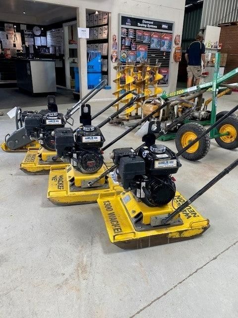A Row of Yellow Vibratory Plates Are Lined Up in a Garage — Hamblin Hire in Albury, NSW