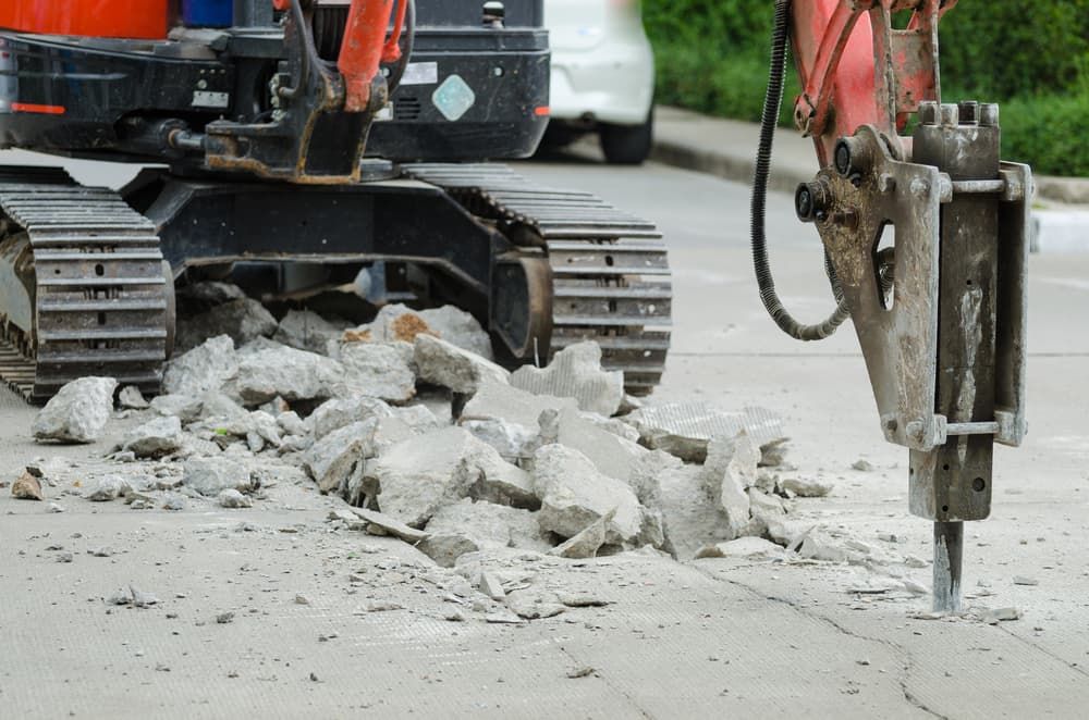 A Bulldozer is Breaking Up Concrete With a Hammer — Hamblin Hire in Albury, NSW