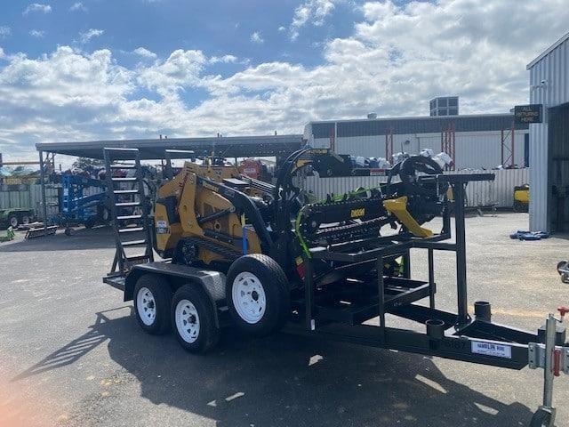 A Trailer With a Tractor on It is Parked in a Parking Lot — Hamblin Hire in Albury, NSW