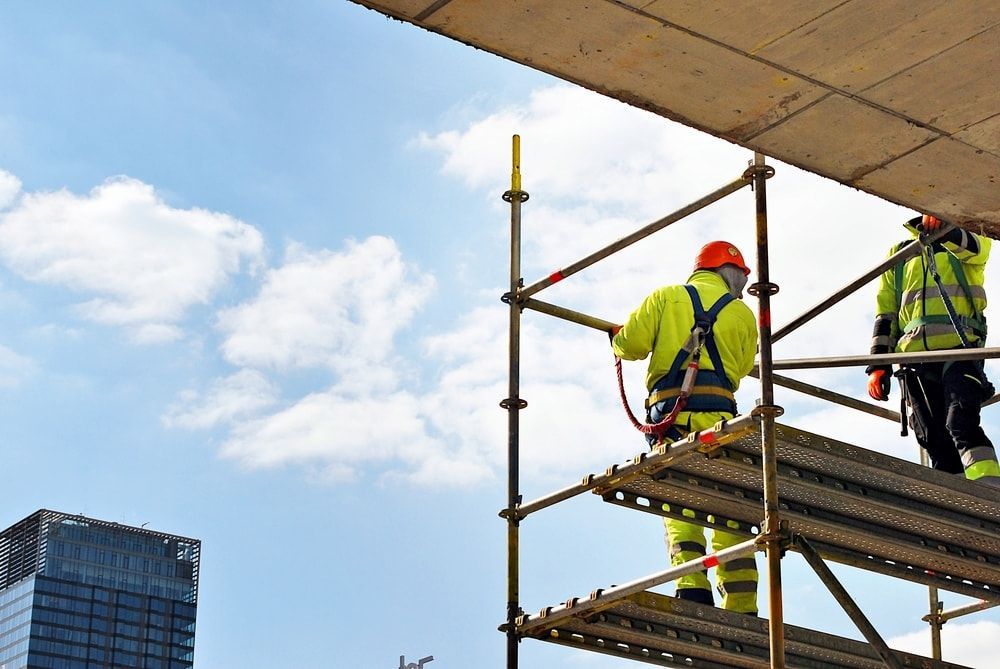 Two Construction Workers Are Standing on Top of a Scaffolding — Hamblin Hire in Albury, NSW