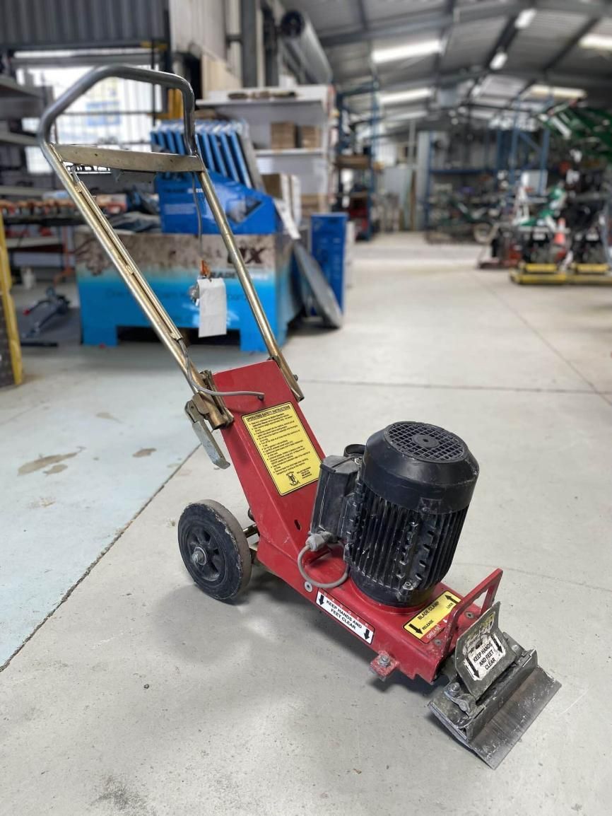 A Red Machine With a Black Motor is Sitting in a Warehouse — Hamblin Hire in Albury, NSW