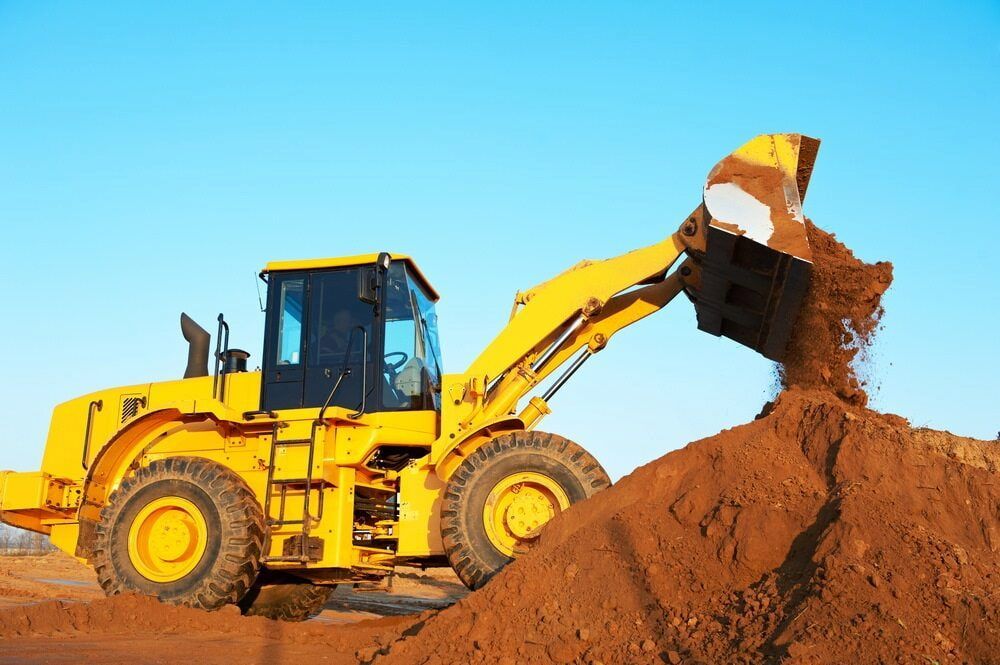 A Yellow Bulldozer is Loading Dirt Into a Pile— Hamblin Hire in Albury, NSW