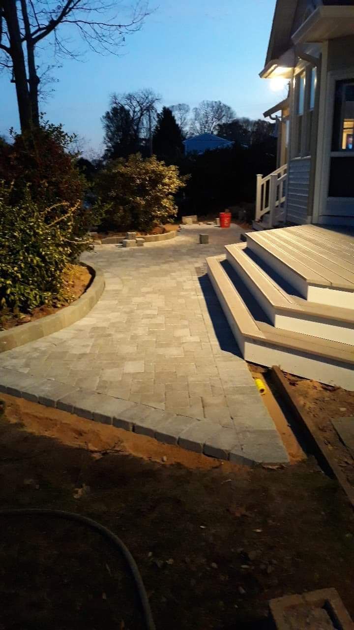 Brick pathway leads to house steps; dusk lighting.