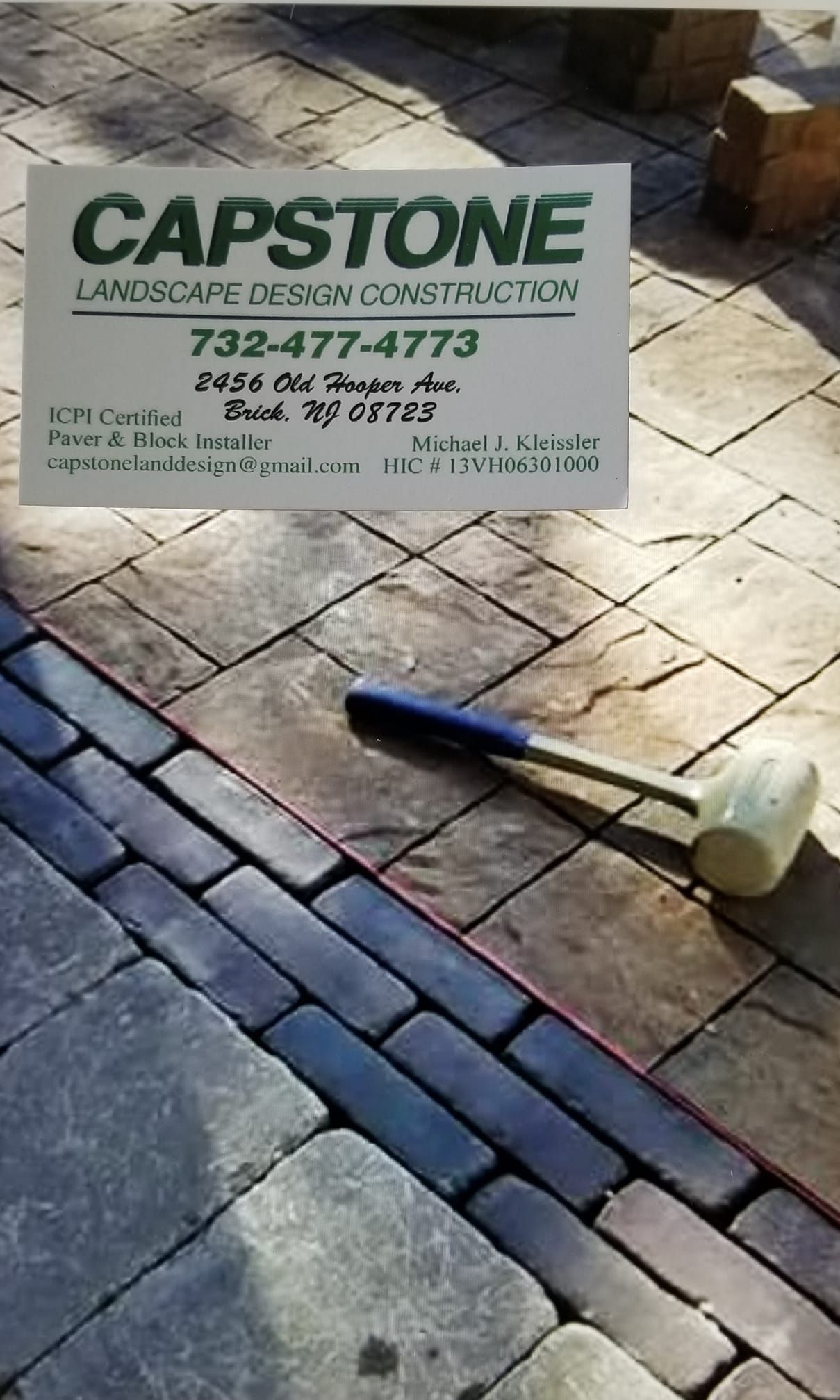 Capstone landscaping sign on pavers with a mallet.