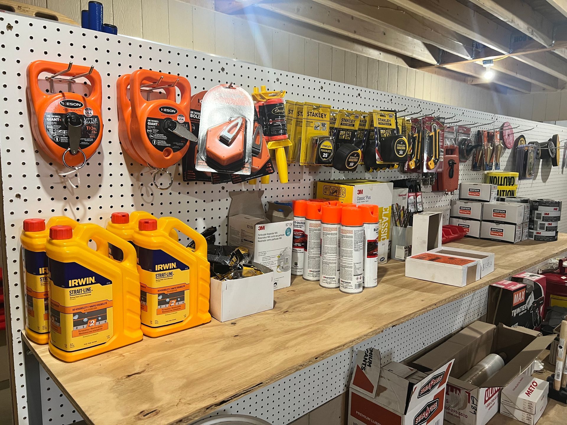 Tools and supplies on display at a hardware store; orange and yellow products are prominent.