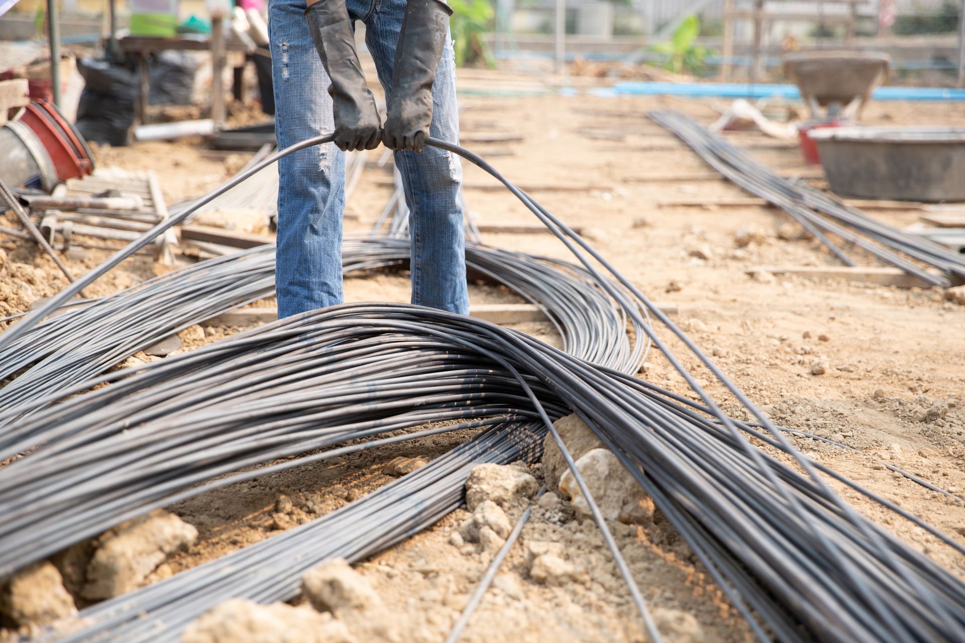 Construction worker handling steel rebar on a construction site.
