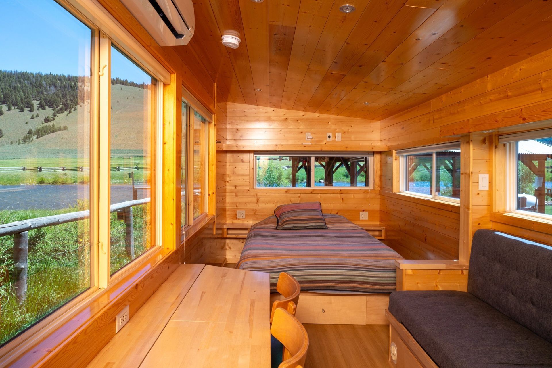 A bedroom with a bed and a lot of windows