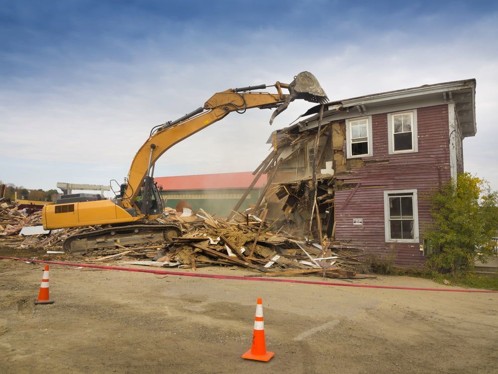 Excavator Demolishing a Red House, Debris Scattered on Ground — Dirt Werx in Narooma, NSW