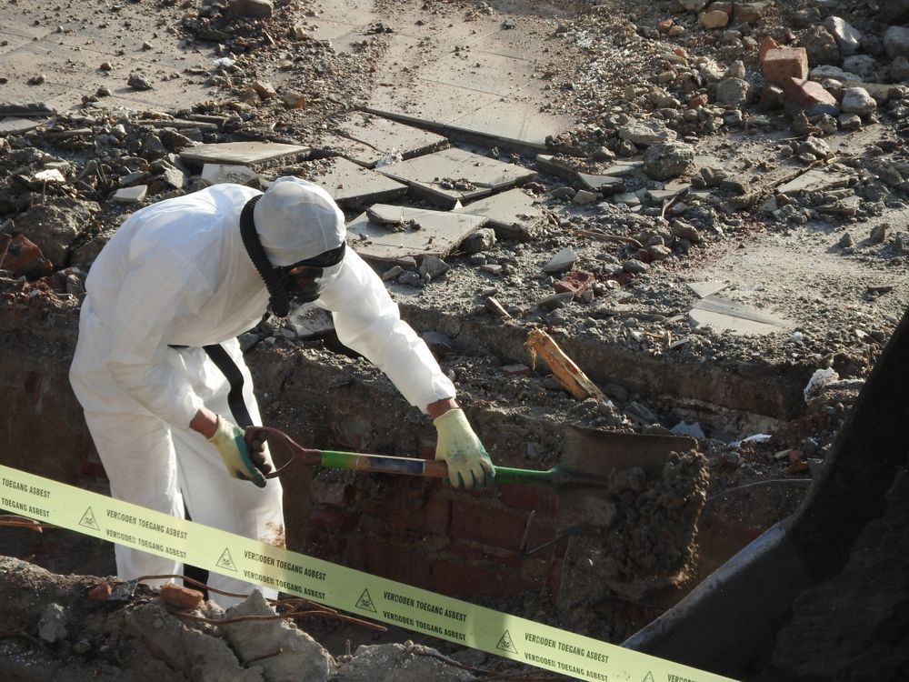 Worker In White Protective Suit Examines A Damaged Area — Dirt Werx in Nowra, NSW