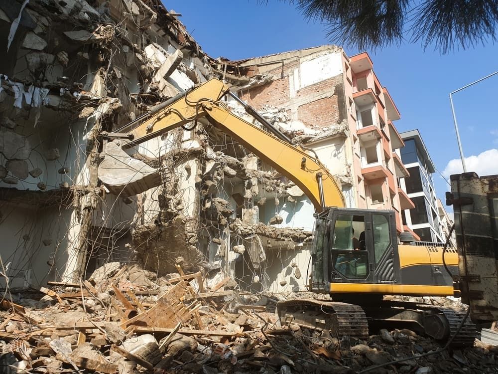 Yellow Excavator Demolishing a Multi-story Building — Dirt Werx in Shellharbour, NSW