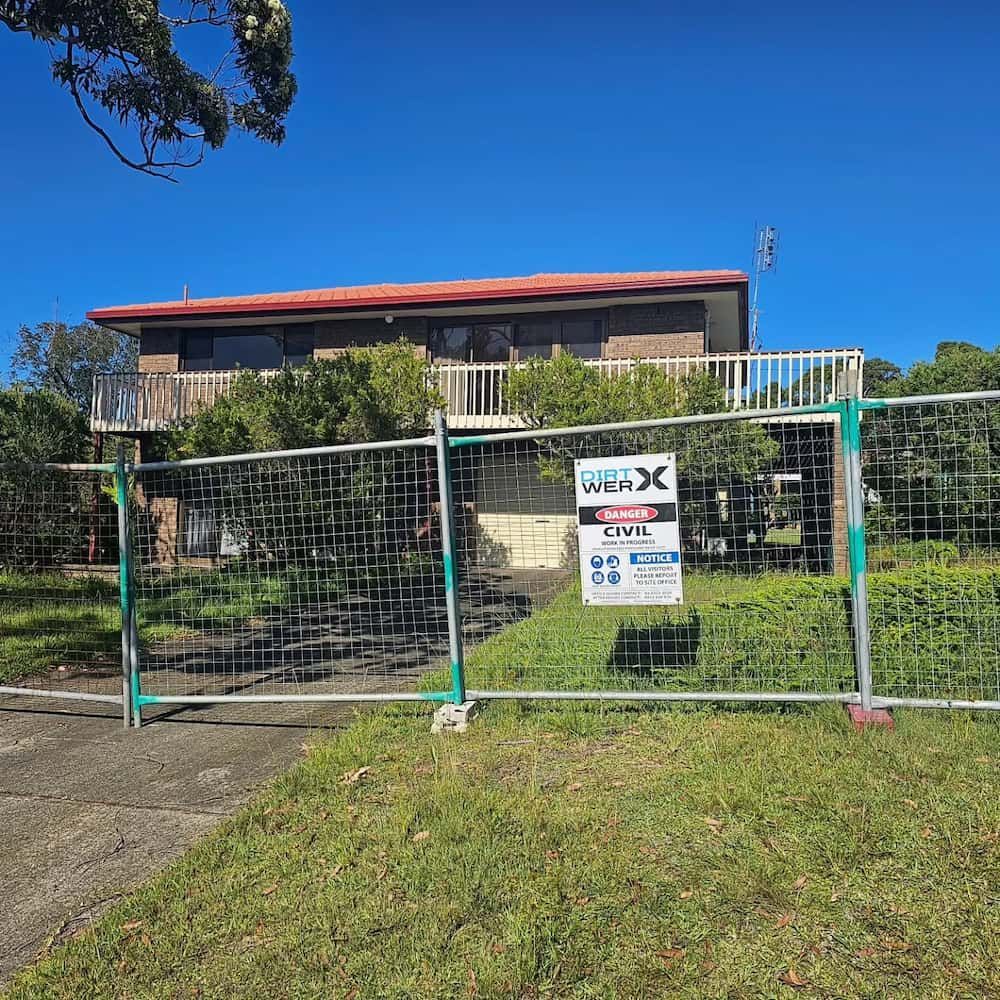 House Behind a Temporary Construction Fence, Overgrown With Greenery — Dirt Werx in Nowra, NSW