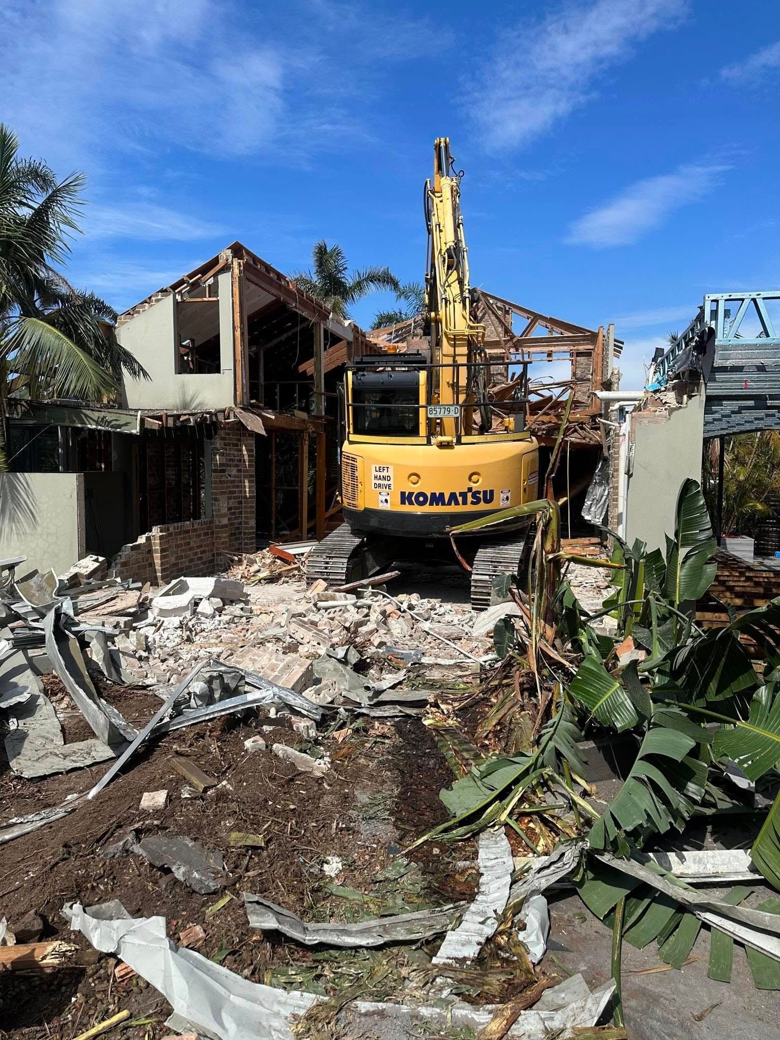 Yellow Excavator Clearing Debris From A Demolished Building — Dirt Werx in Maitland, NSW