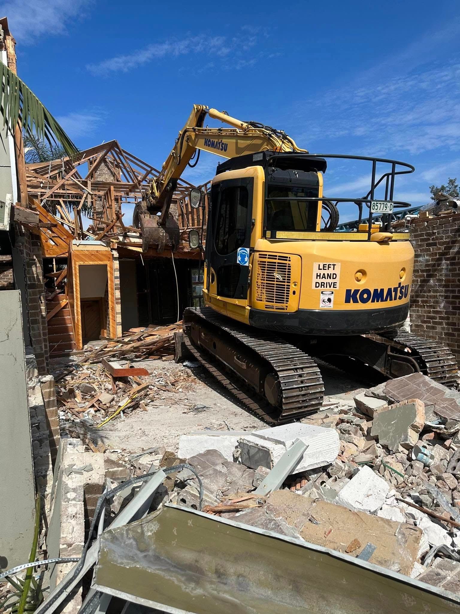 Yellow Excavator Demolishing A Brick Building Amid Rubble — Dirt Werx in Newcastle, NSW