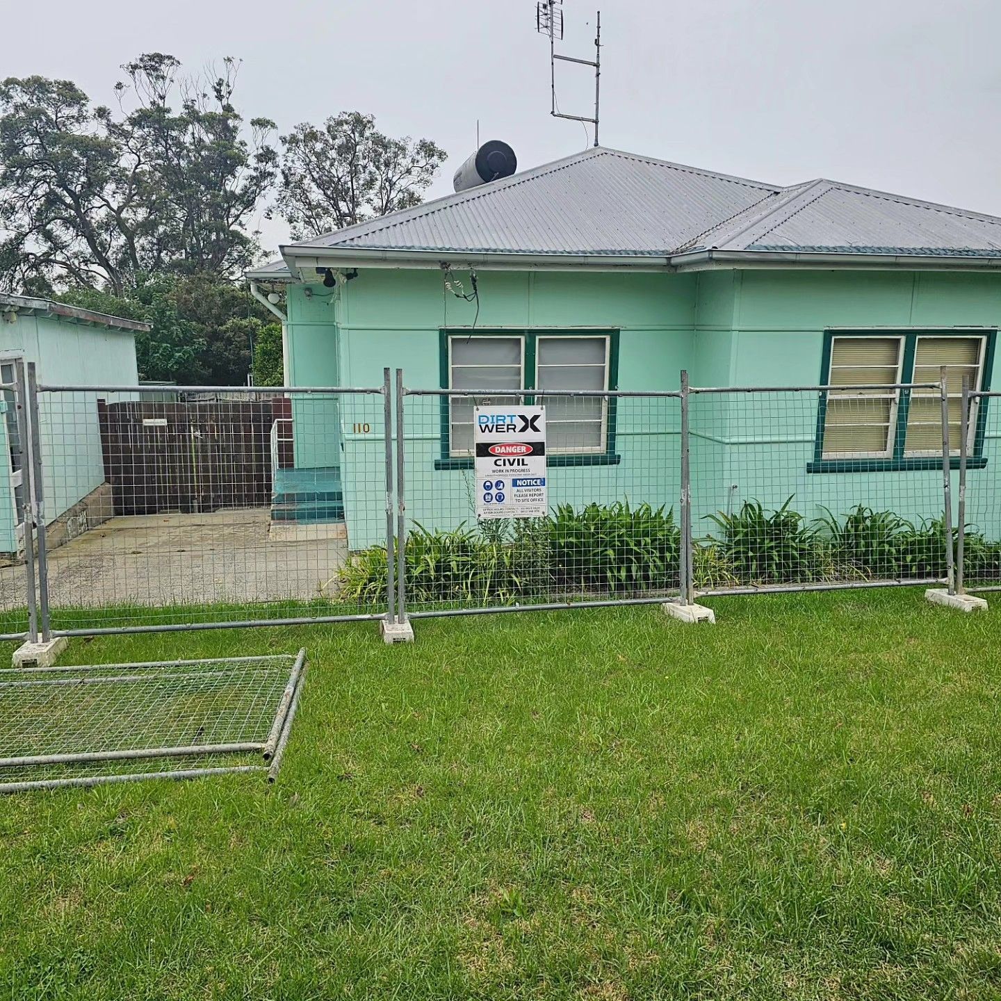 Mint Green House With A Fenced Front Yard And A Gate For Demolition — Dirt Werx in Fingal Bay, NSW
