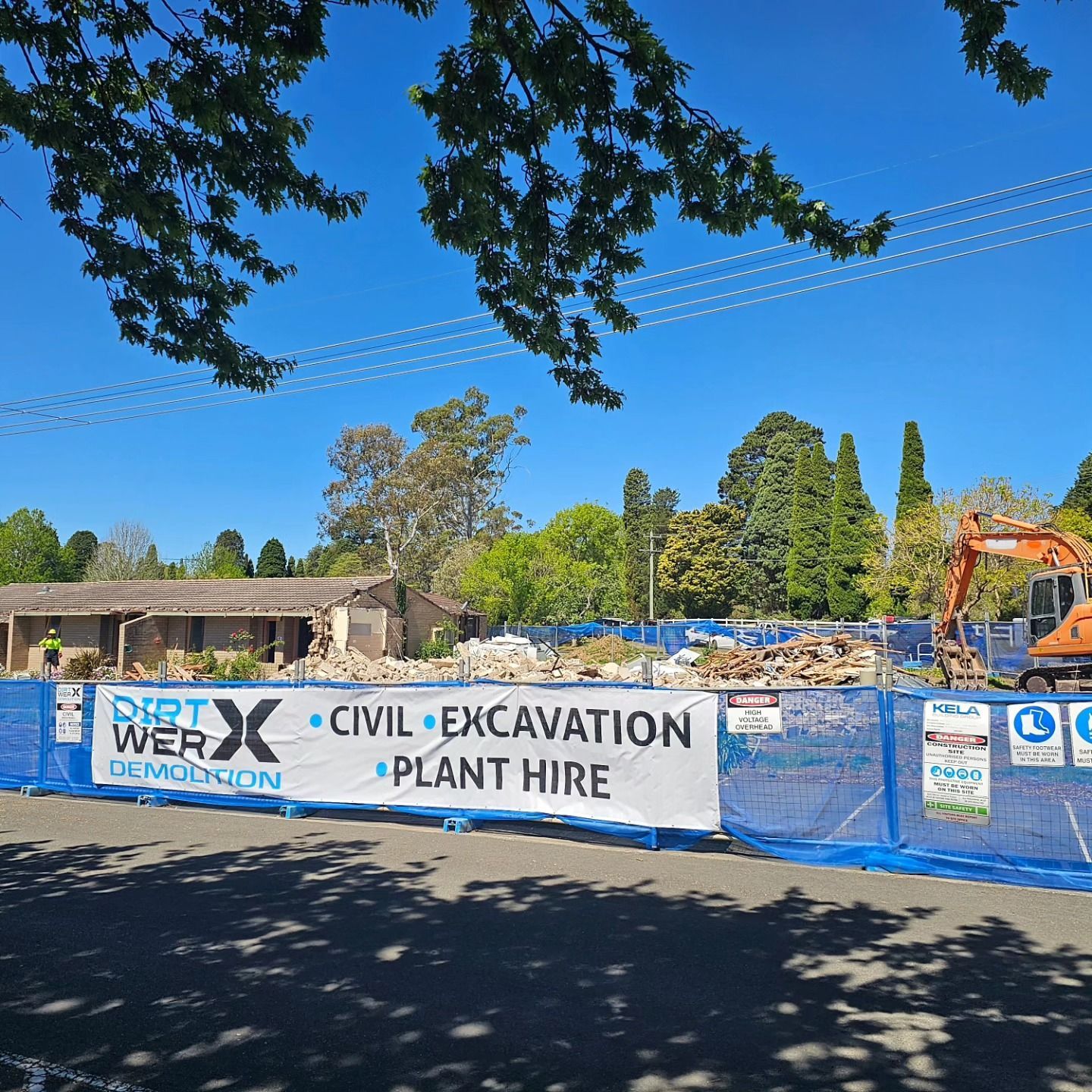 Demolition Site With Blue Fence And Sign For Protection — Dirt Werx in Port Stephens, NSW