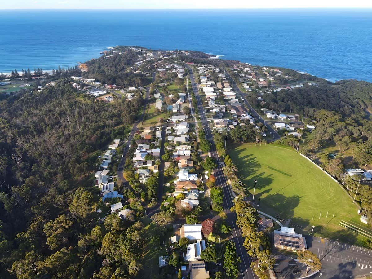 Aerial View of a Coastal Town With Houses, Green Spaces, and the Ocean — Dirt Werx in Tathra, NSW