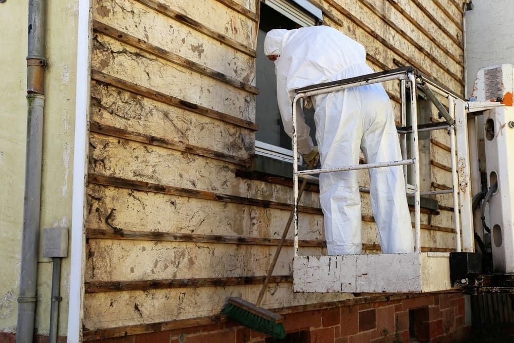 Person in Protective Suit on Lift, Removing Siding From House — Dirt Werx in Southern Highlands, NSW