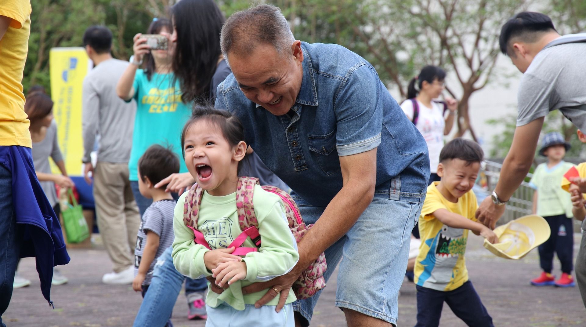 A man is holding a little girl in his arms.