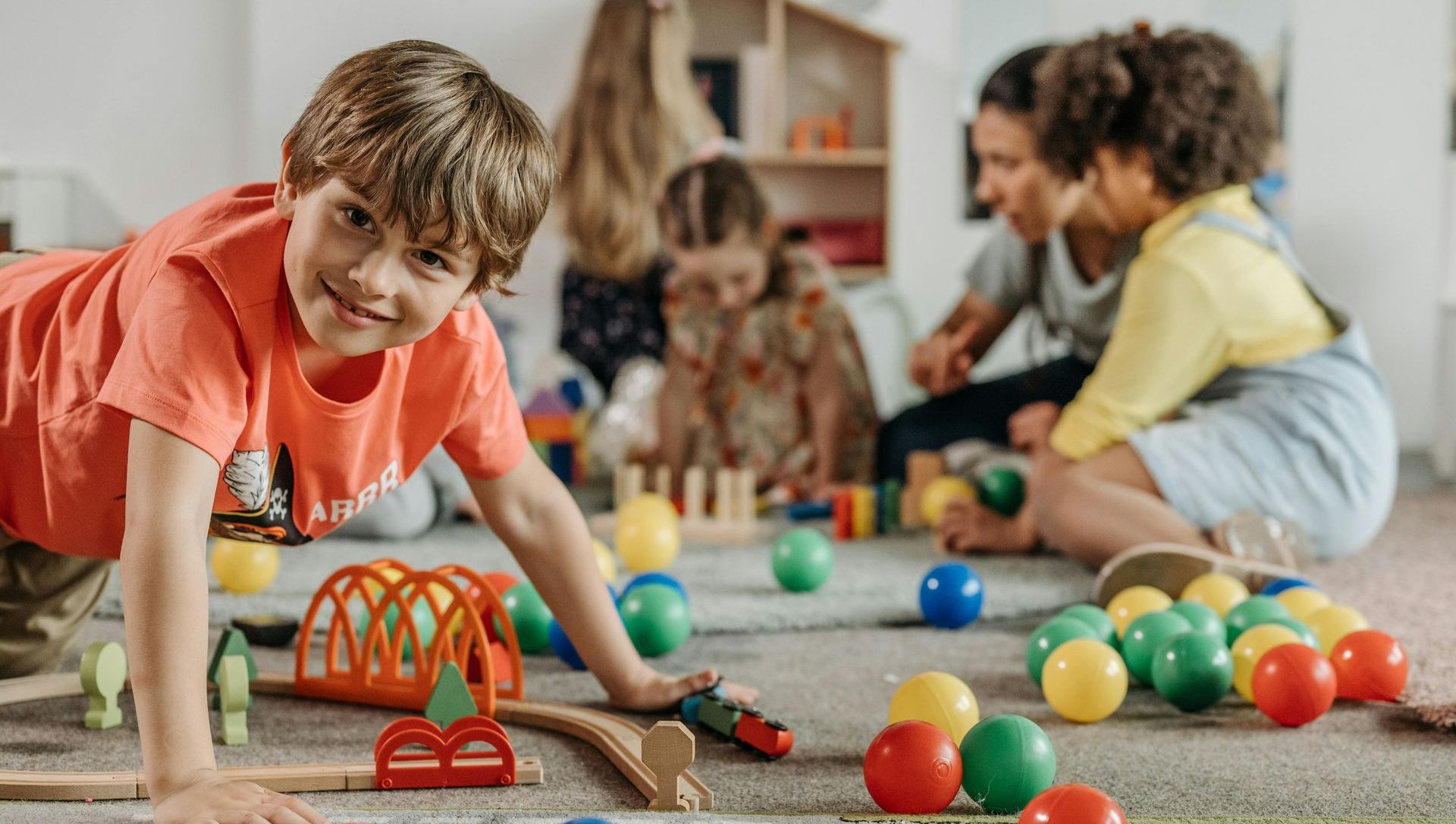 A group of children are playing with toys on the floor.