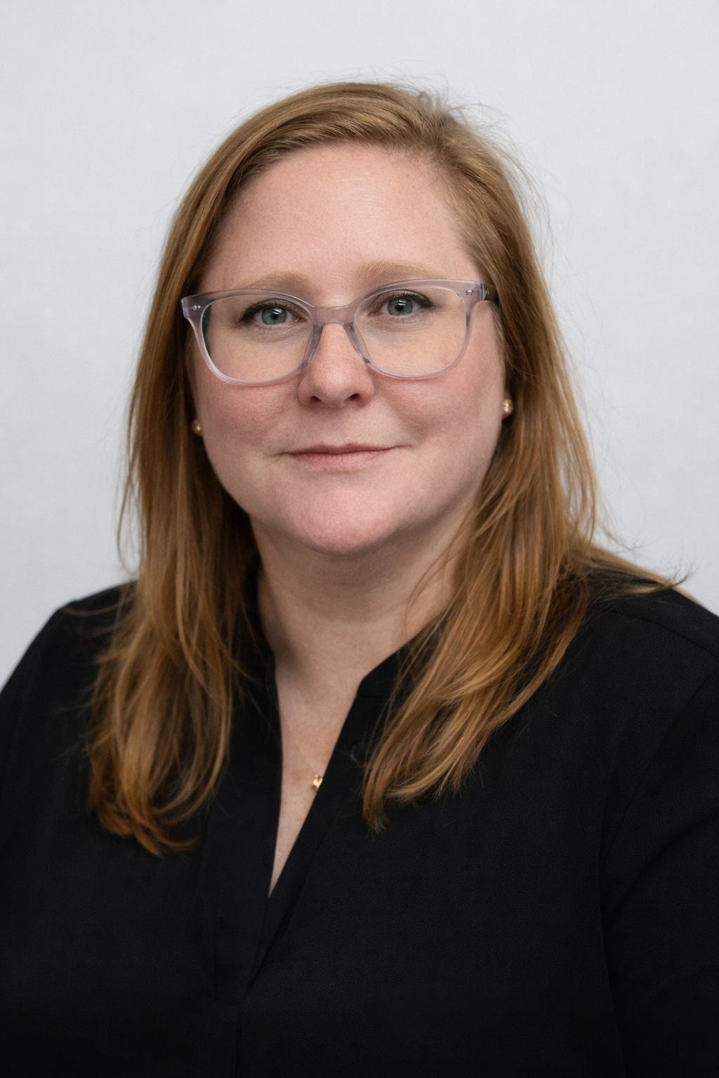 Woman in professional attire, hair pulled back, face obscured.