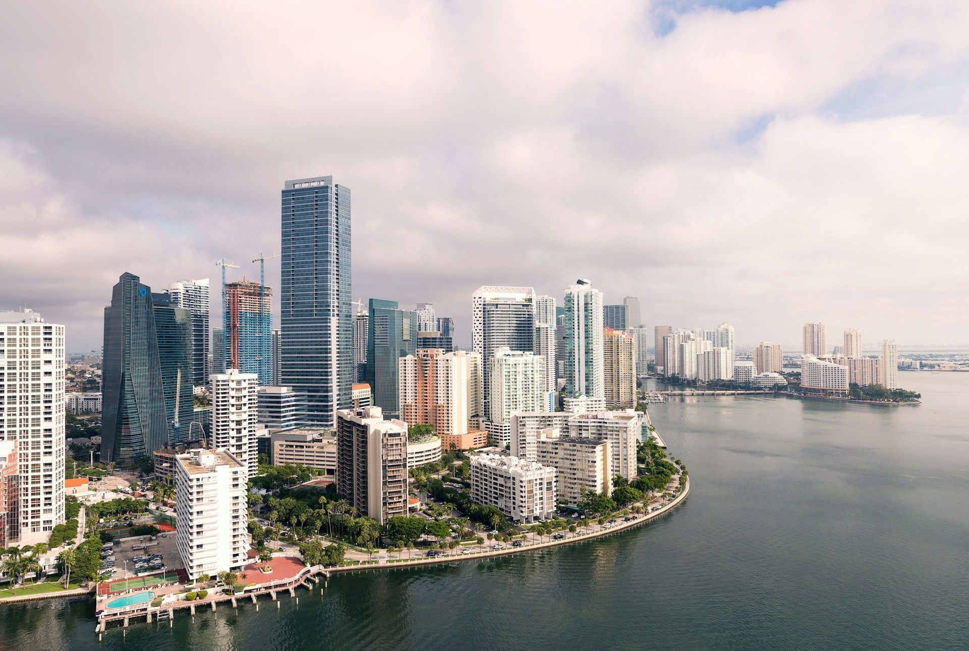 Miami skyline, view of high-rise buildings along a waterfront under a cloudy sky.