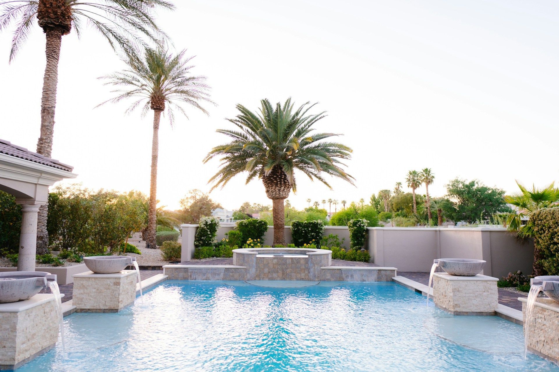 Pool with turquoise water, palm trees, and stone accents under a sunny sky.
