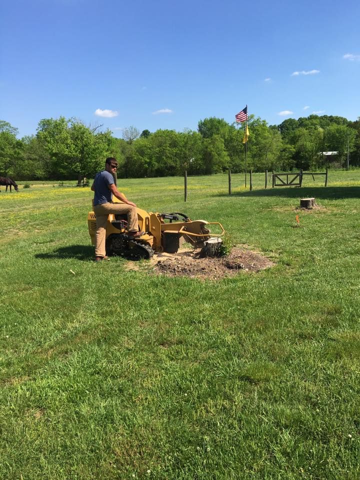 Person operating a wood chipper in a grassy park on a sunny day