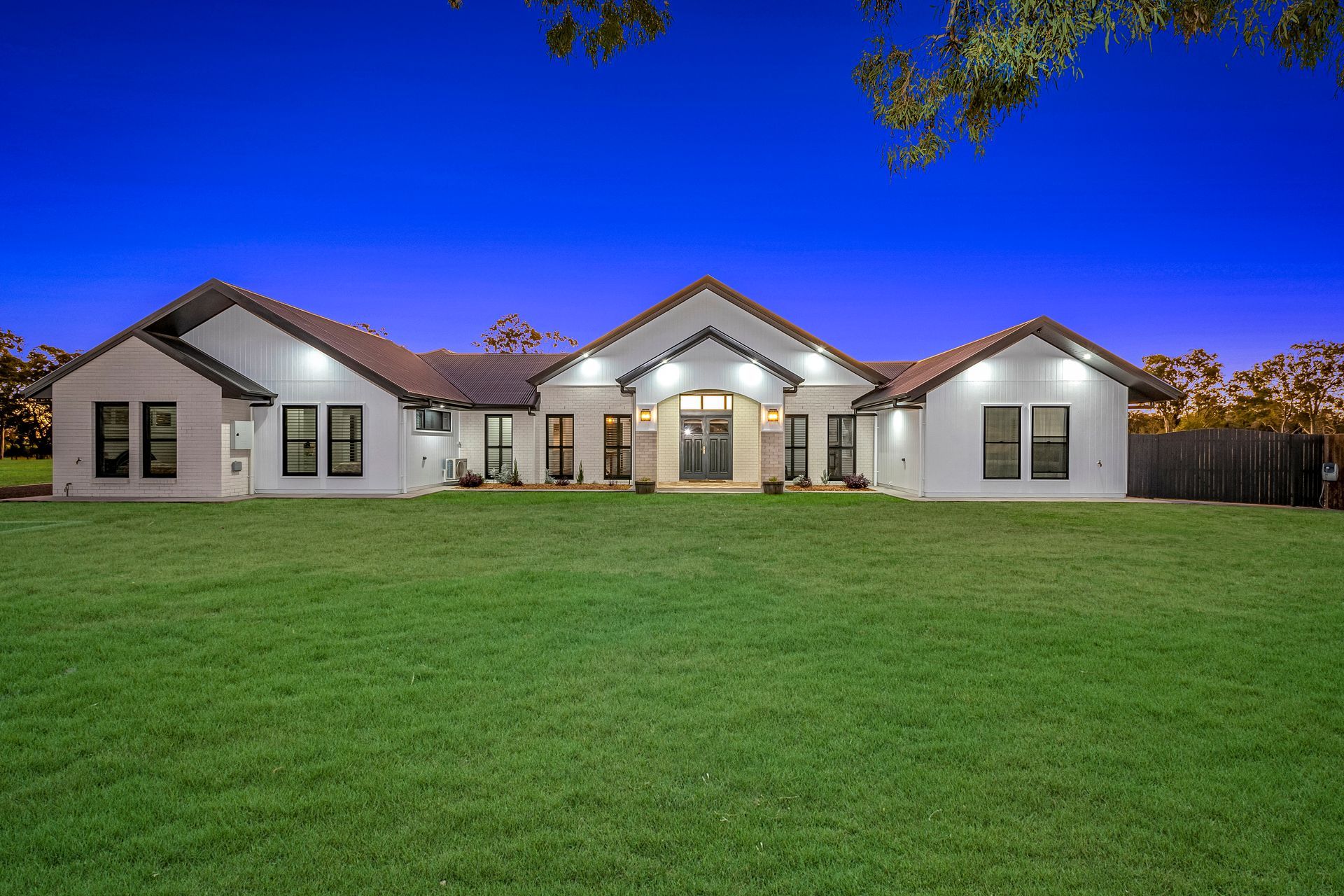 Single-Story White House with Lit Windows — Gatley Building Design in Gin Gin, QLD