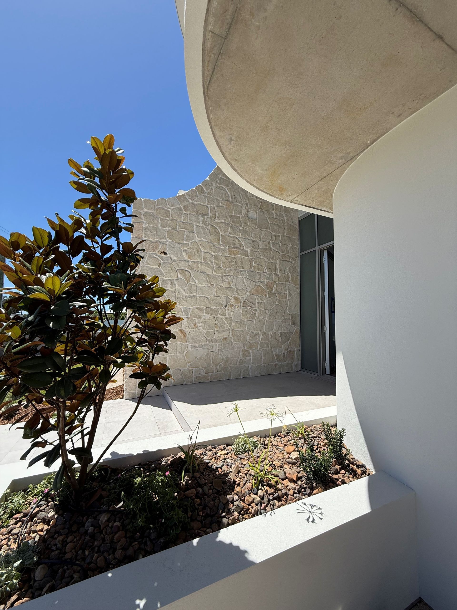 Modern Courtyard with White Walls, Stone Path — Gatley Building Design in Bundaberg East, QLD