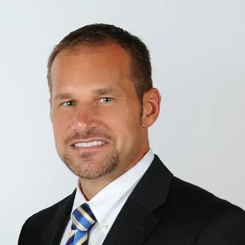 A man in a suit and tie is smiling for the camera