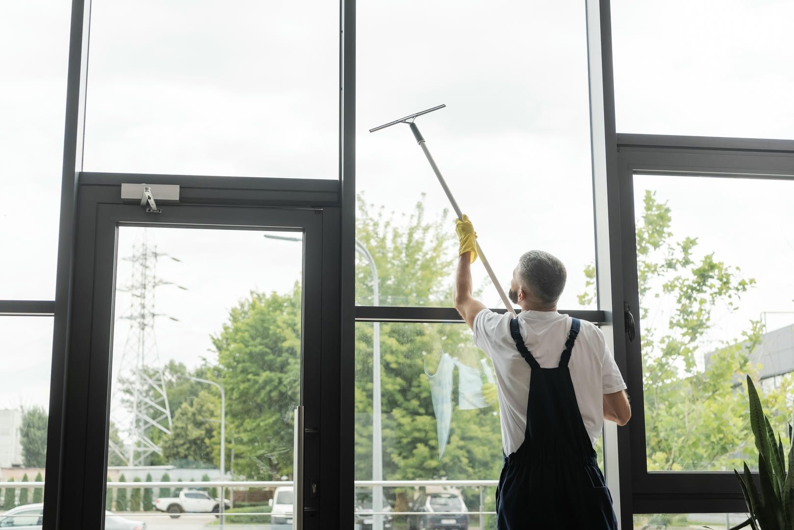 A man is cleaning a window with a squeegee.