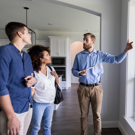 A man is pointing at a window while a woman looks on.
