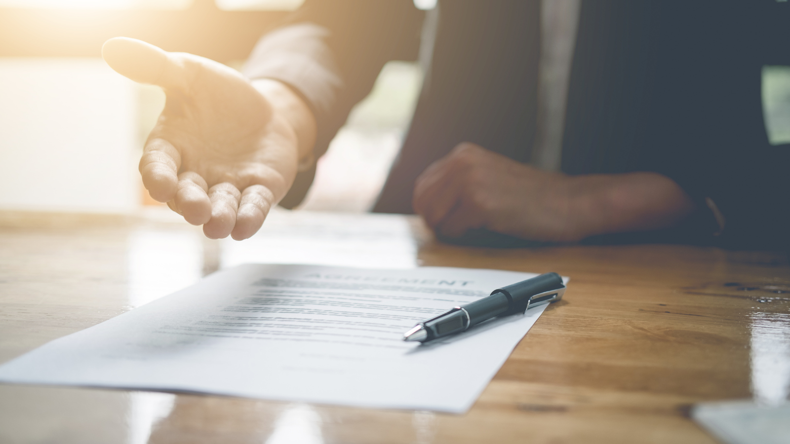 a person is sitting at a table with a pen and a piece of paper .