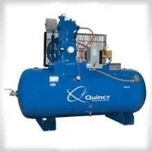 A blue air compressor is sitting on top of a blue tank.