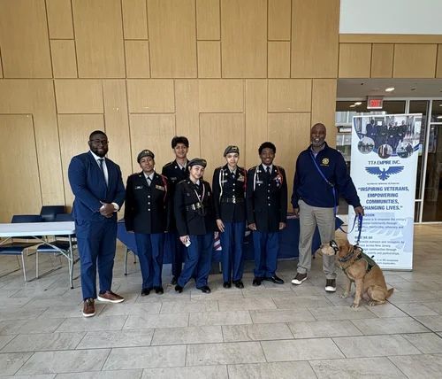 Group in navy uniforms posing indoors with two adults and a dog Group in navy uniforms posing indoors with two adults and a dog