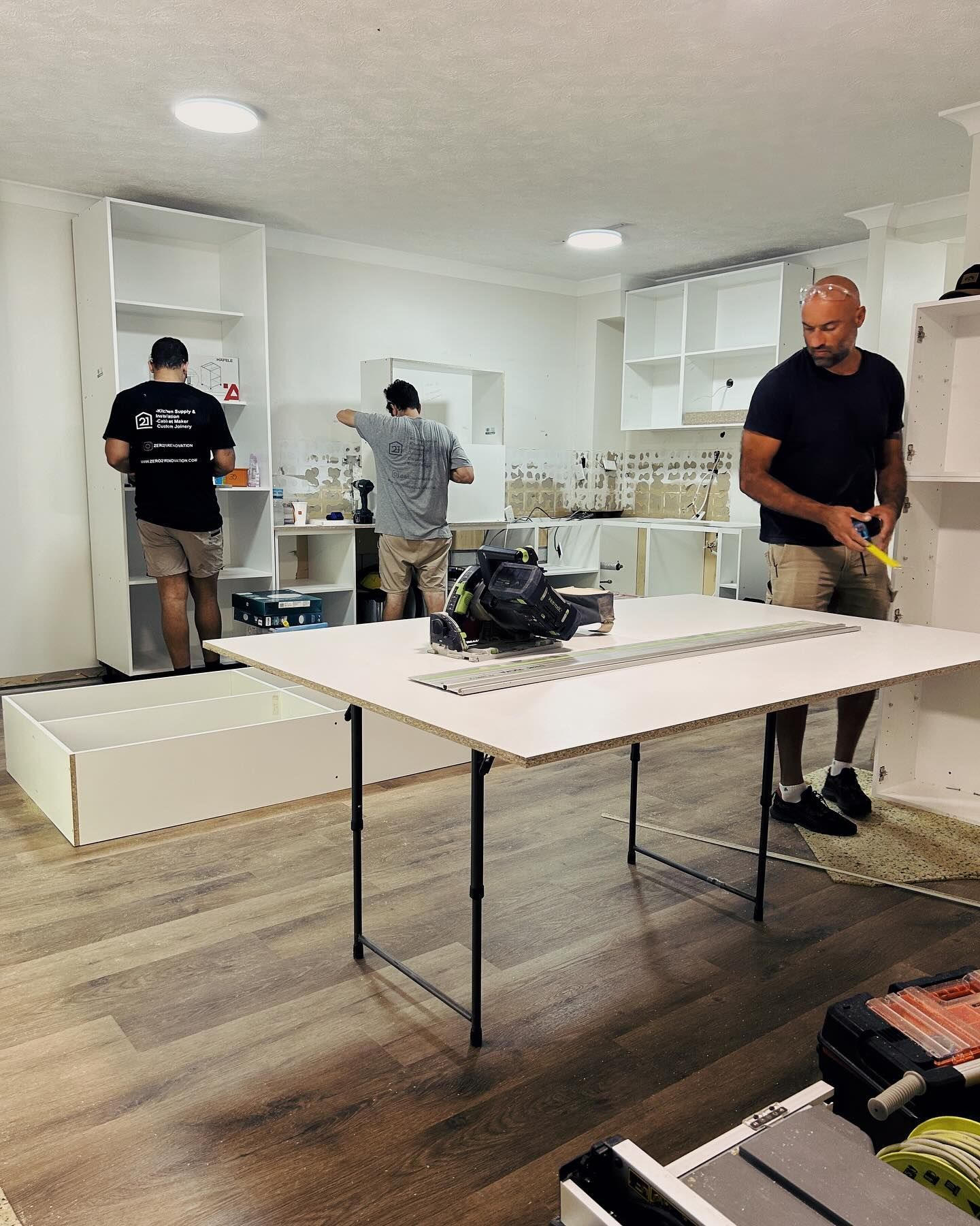 Three Men Assemble Shelving — Zero 21 Fit-Outs & Joinery: Kitchen Renovation Gold Coast in Molendinar, QLD