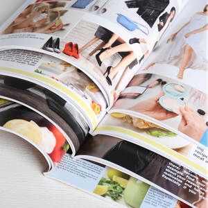Open glossy magazine spread with fashion and beauty photos on a white surface